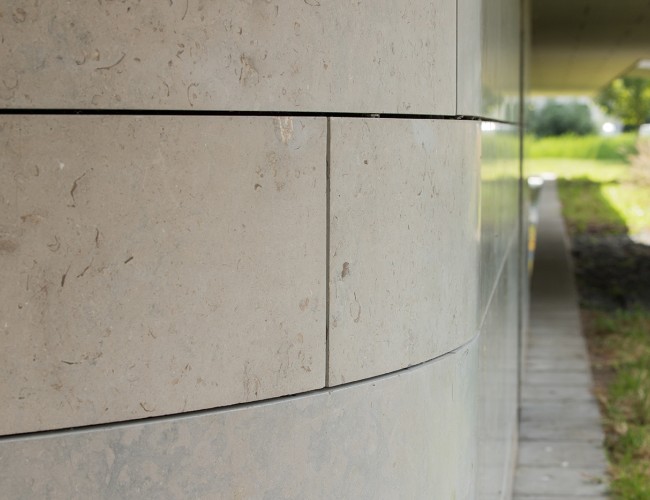 Gevelbekleding van natuursteen met afgeronde hoeken